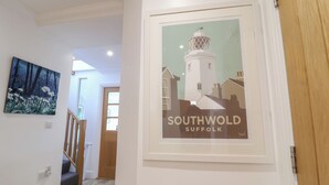 Käytävällä on kehystetty valokuva majakasta, ja sen alla on teksti: ”Southwold, Suffolk”.