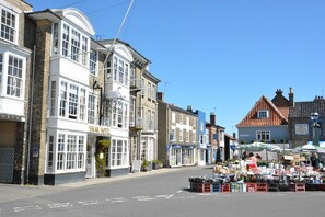 A street with a hotel named 'Swan Hotel' and a market stall area. - Saffron, Blythview (Halesworth)