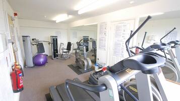 A gym with treadmills, elliptical machines, and a stationary bike.