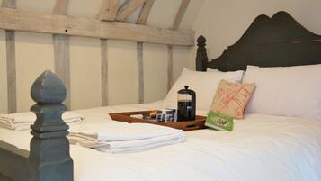 A neatly made bed with a tray of breakfast items, a pillow, and a bedside table.