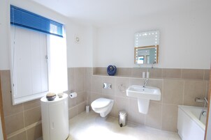 Un baño moderno con inodoro, lavamanos y bidé.