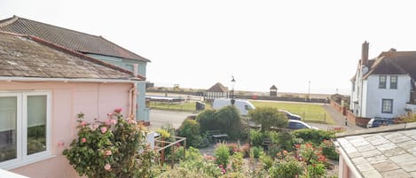 A residential area with houses, a garden, and a view of the sea.