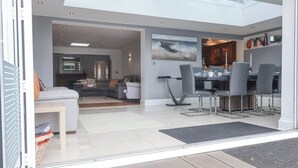 Un salon moderne comprenant un canapé, une table basse et un coin repas avec des chaises et une table.