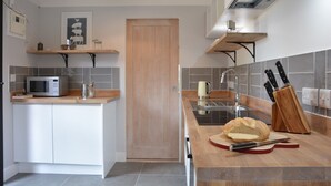 A modern kitchen with a microwave, kettle, and bread on the counter. - Milk Parlour (Halesworth)