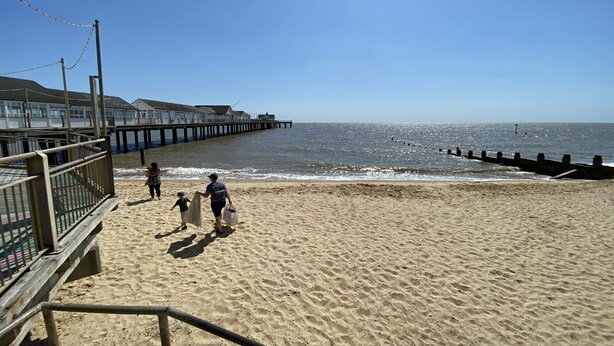 A beach with a wooden boardwalk and a pier extending into the water. - Walton House, Southwold (Reydon)