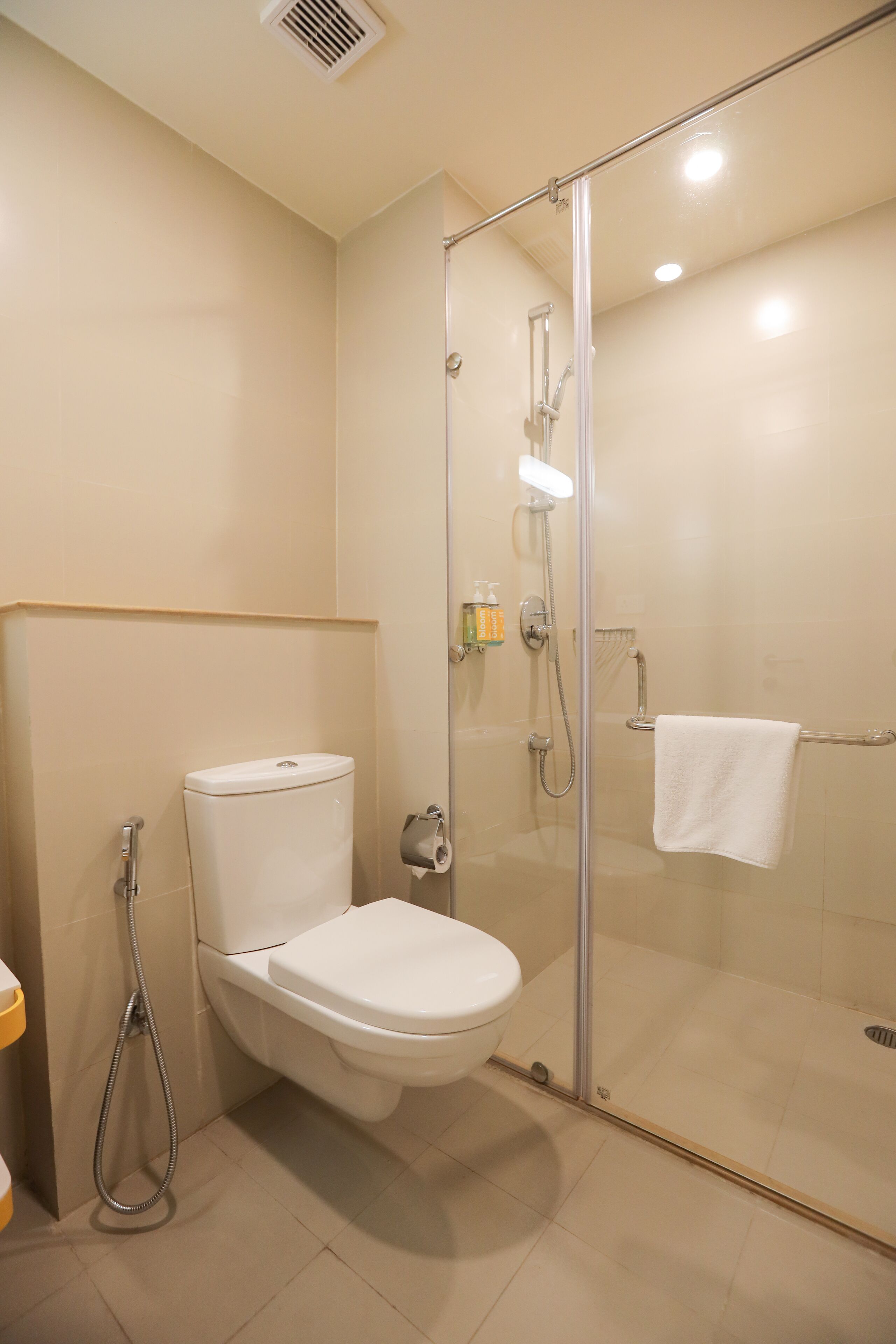 A bathroom with a toilet, a glass-enclosed shower, and a towel rack.