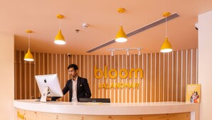 Un comptoir d’accueil avec un revêtement en bois et un design moderne, agrémenté d’un logo et d’une plaque nominative.