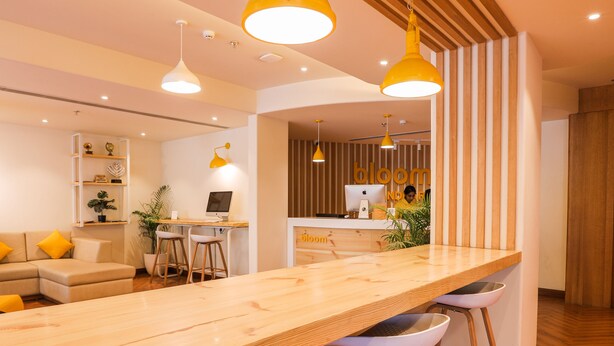 Une cuisine moderne avec des plans de travail en bois, des tabourets de bar et des luminaires suspendus.