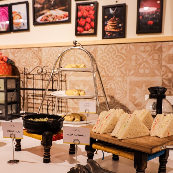 A buffet setup with labeled food items including sprout salad and plain sandwiches.