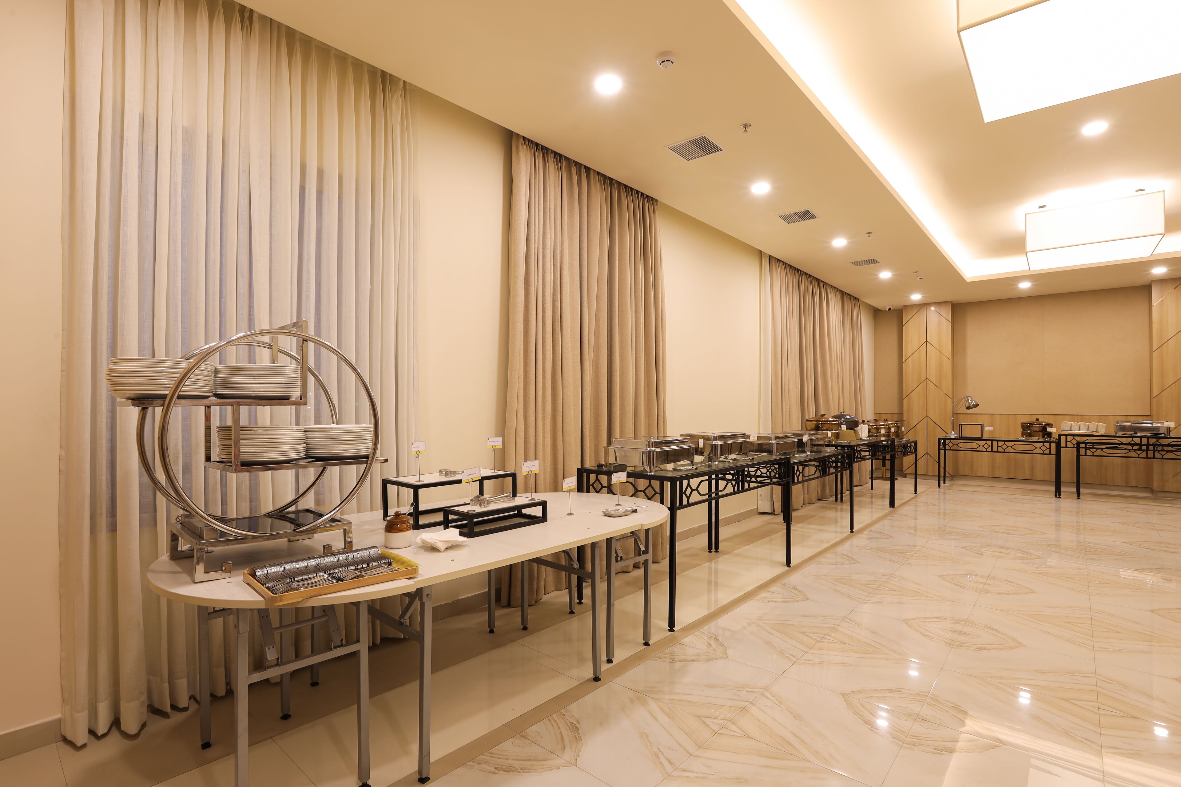 Una sala de conferencias con una larga mesa, sillas y mesas de buffet.