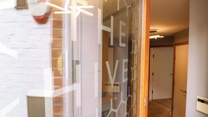 Un intérieur moderne avec une cloison en verre, un mur en briques blanches et un plancher en bois.
