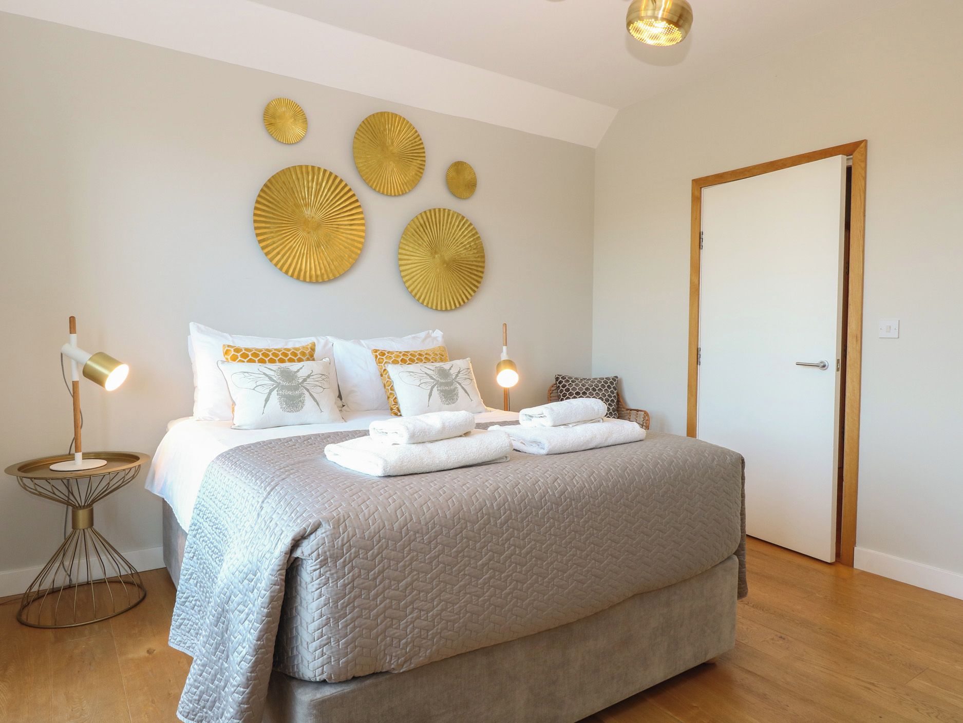 Ein Schlafzimmer mit einem Bett, Nachttischen und dekorativen Wandbildern.