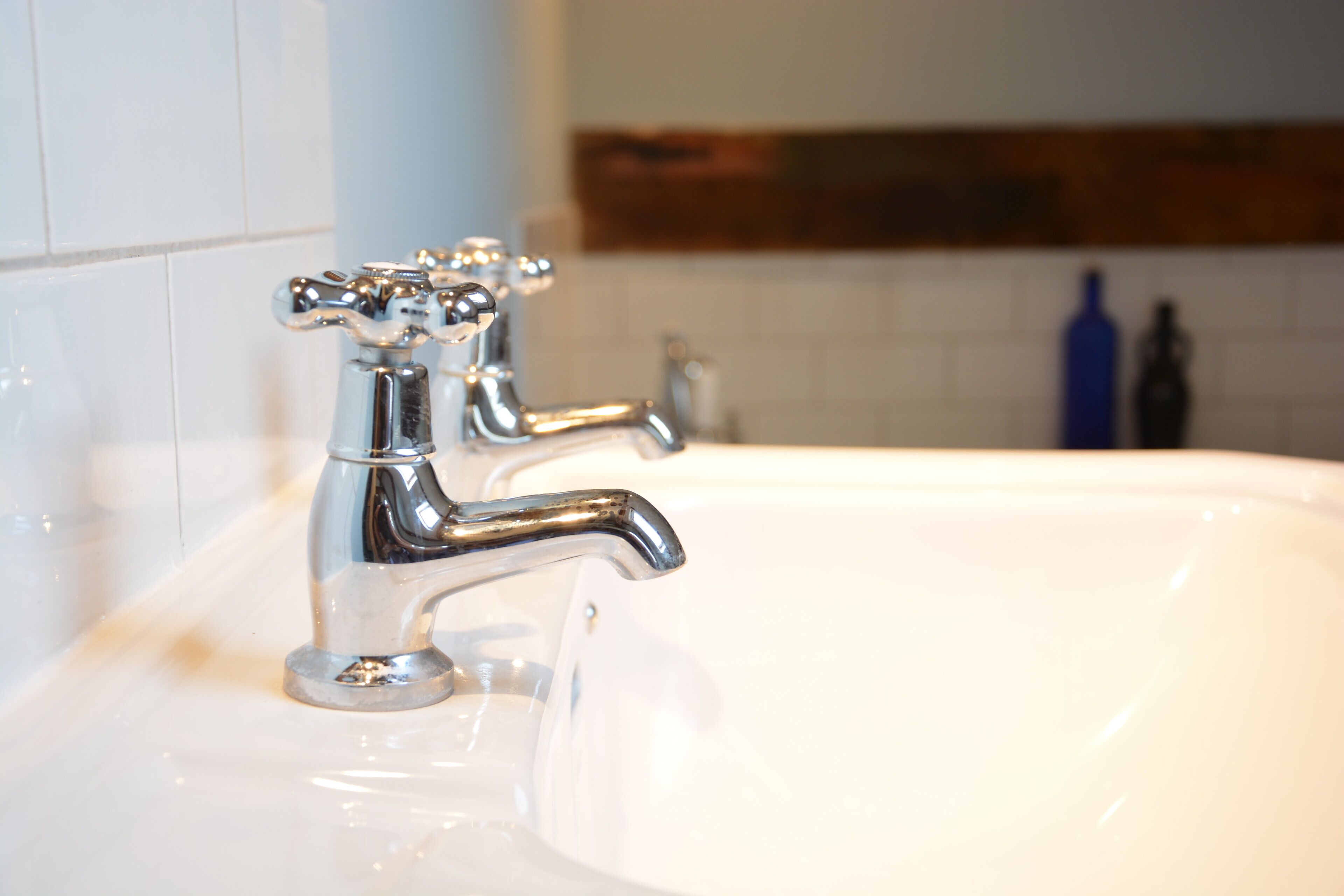 Ein Waschbecken mit chromfarbenen Armaturen und einer weißen Arbeitsplatte.