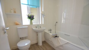 Ein Badezimmer mit Toilette, Waschbecken und Badewanne.