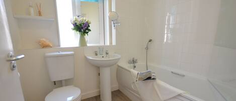 A bathroom with a toilet, sink, and bathtub.