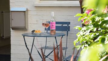 A table with a bottle of French rosé wine, two glasses, and a bowl of fries.