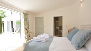 Un dormitorio con cama, ventana y puerta.