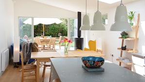 Una cocina moderna con comedor, ventanas amplias y vistas al exterior.