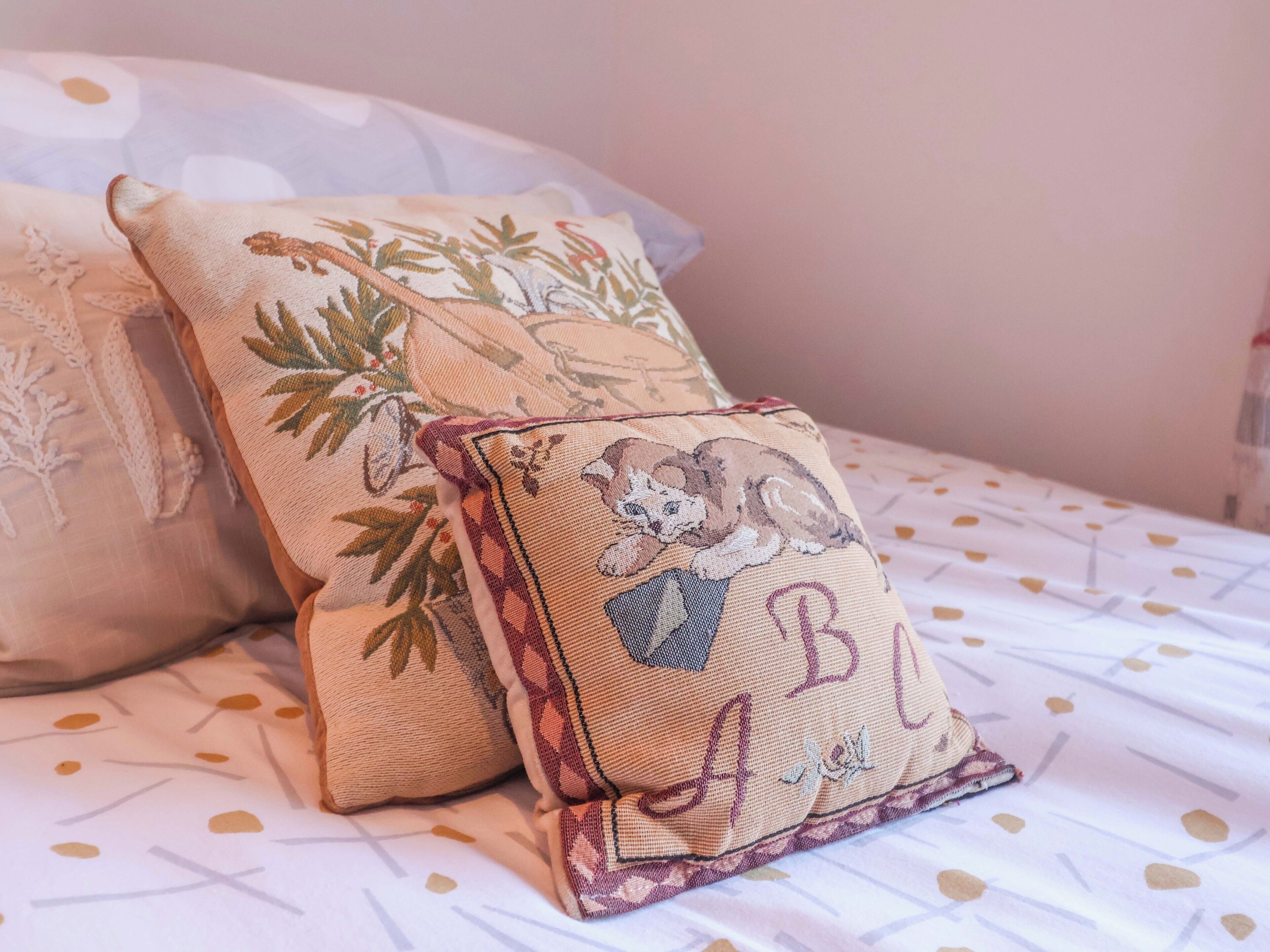 Two pillows on a bed with a patterned bedspread.