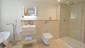 A modern bathroom with a glass-enclosed shower, a white sink, and a toilet. - Carriage House, Bruisyard (Saxmundham)