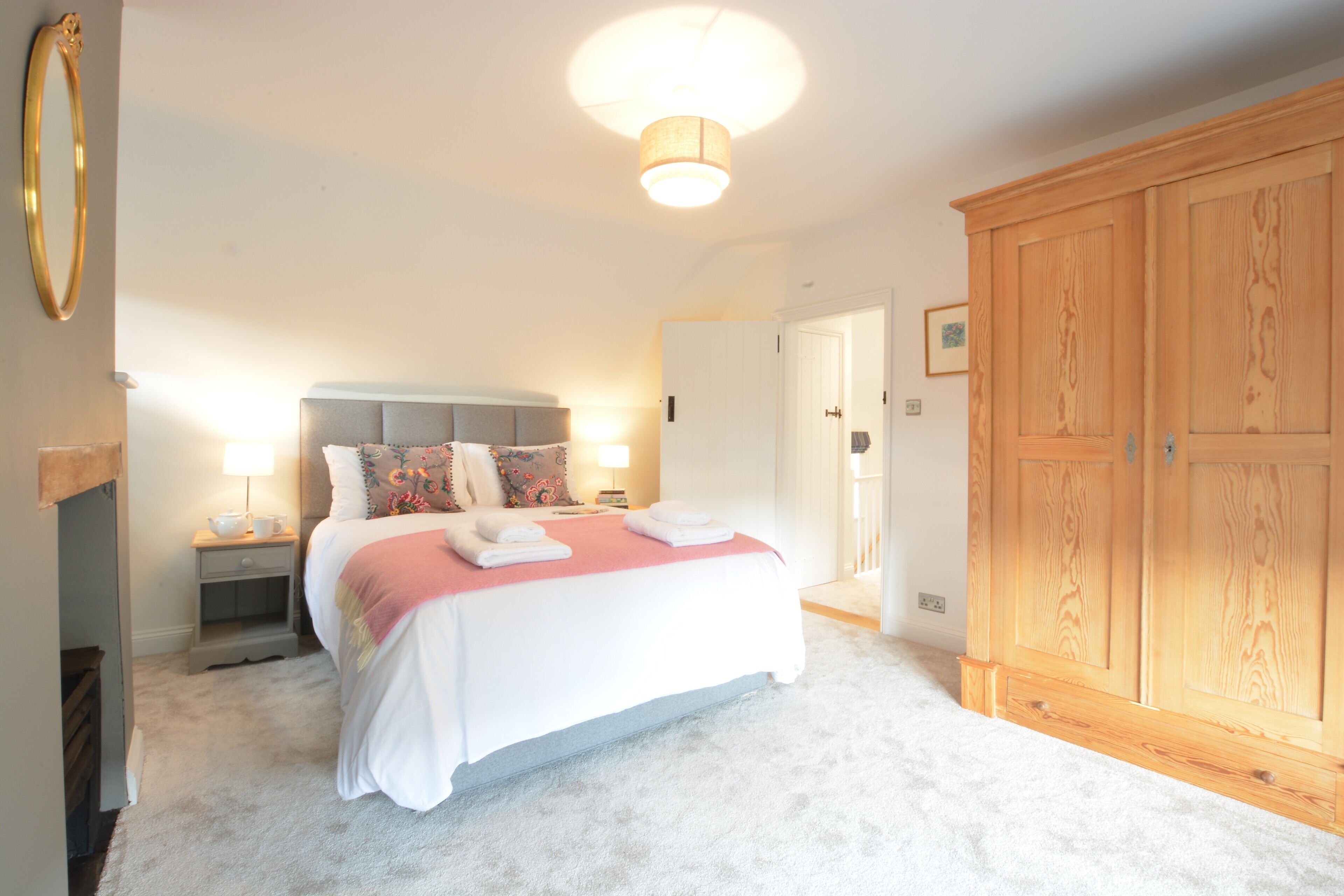 A bedroom with a bed, bedside tables, a wardrobe, and a ceiling light.