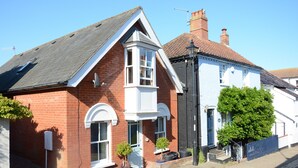 A traditional red brick house with a white front door, a small porch, and a window with a white frame. - The Red Brick House, Aldeburgh (Aldeburgh)