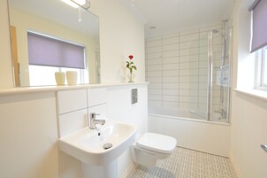 A bathroom with a sink, toilet, and shower.