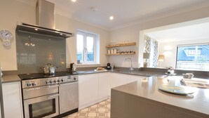 Una cocina moderna con electrodomésticos de acero inoxidable, una isla grande y un ventanal que proporciona luz natural.