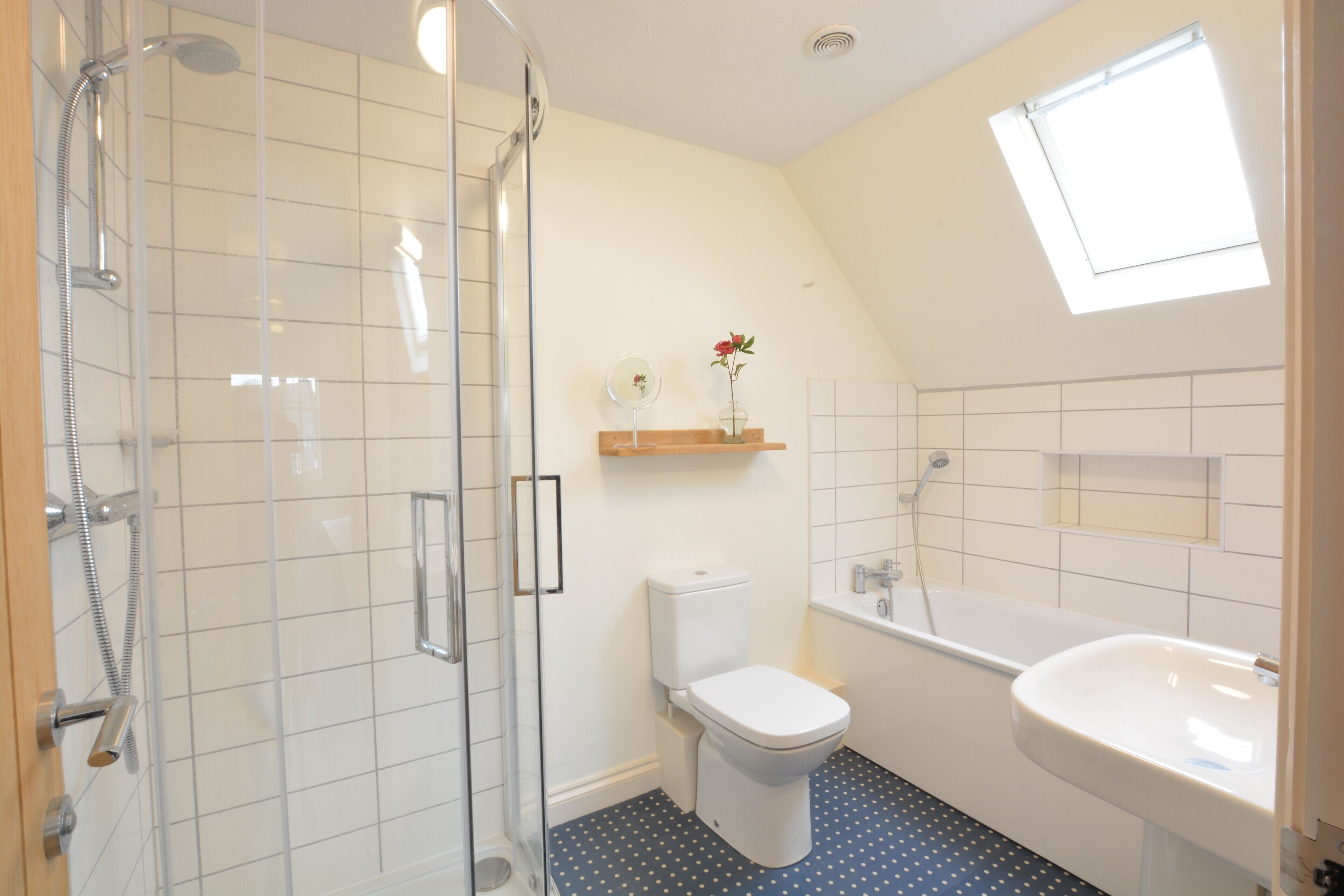 A bathroom with a glass-enclosed shower, a toilet, a bathtub, and a sink.