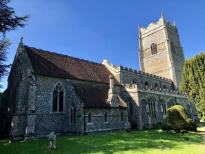 A historic church with a prominent tower and a well-maintained lawn. - Rectory Farm Cottage, Rougham (Bury St Edmunds)