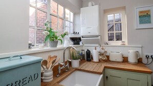 A kitchen with a sink, countertop, and a bread box. There are windows, a refrigerator, and a microwave. - Rosemary Cottage, Aldeburgh (Aldeburgh)