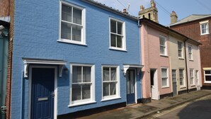 A row of terraced houses with distinct blue and pink facades, white windows, and doors. - 53 Tern Cottage, Aldeburgh (Aldeburgh)
