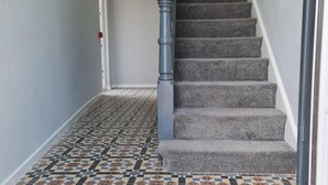 A staircase with carpeted steps and a patterned tile floor. - Luxury Apartment - Free Wi-fi & Parking NO Deposit (Coventry)