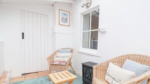 A cozy room with a wicker chair, a small wooden table, and a wicker sofa.