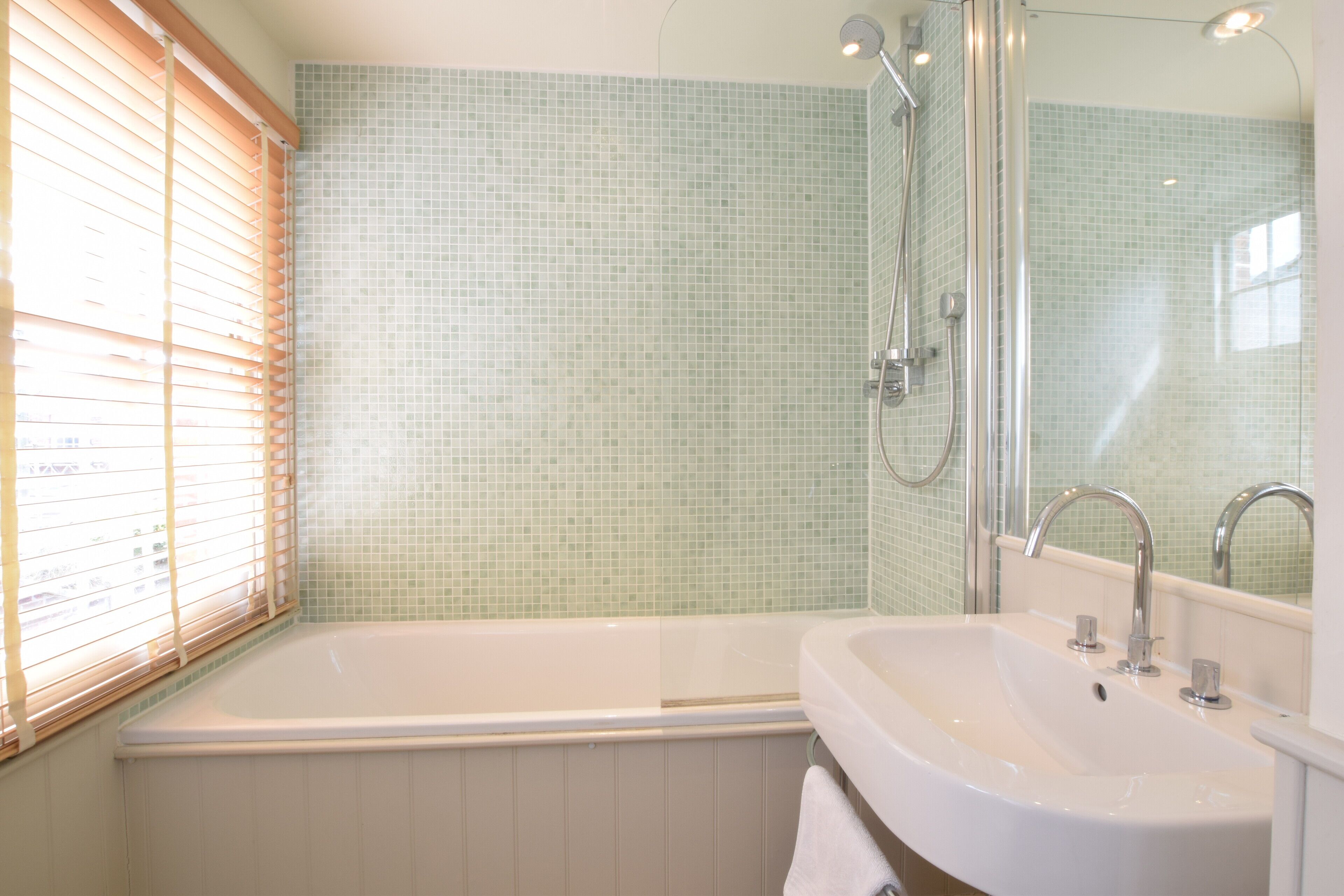 A bathroom with a bathtub, a sink, and a shower.