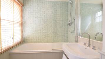 A bathroom with a bathtub, a sink, and a shower.