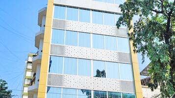 Stunning building with a prominent sign, large windows, and a patterned facade surrounded by lush greenery.
