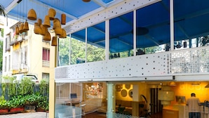 A modern building with large windows, hanging wicker lamps, and a visible storefront with a sign. - Bloom Boutique - Bandra (Mumbai)