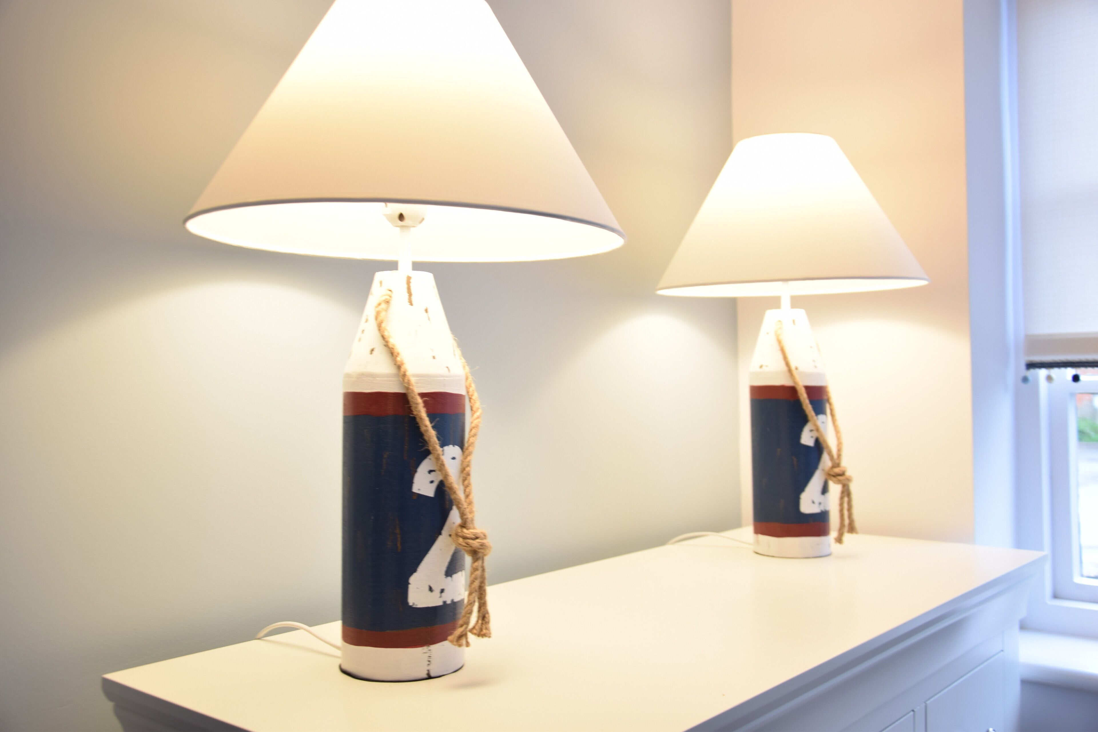 Two lamps with nautical-themed designs on a white surface.