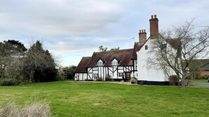 A traditional Tudor-style house with a large lawn and mature trees. - Church Farmhouse, Cookley (Halesworth)