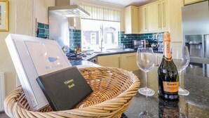 A kitchen with a wicker basket containing a visitors book and a bottle of Canti Prosecco DOC wine. - The Hide Out, Aldeburgh (Aldeburgh)