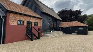 A traditional building with a steeply pitched roof, a brick facade, and a gravel driveway. - Halcyon Barn, Wissett (Halesworth)