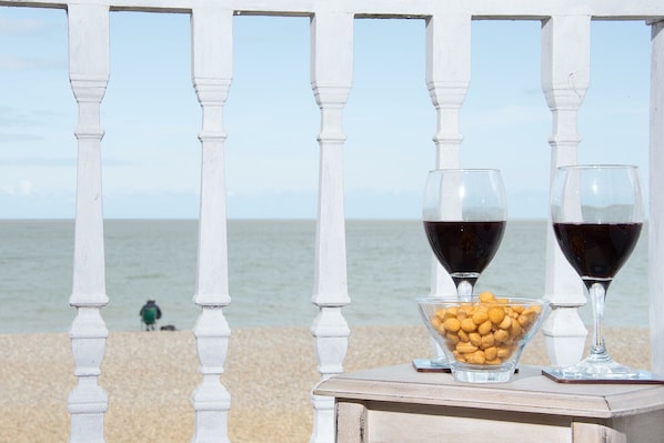Un balcon doté de balustrades blanches donnant sur une plage.