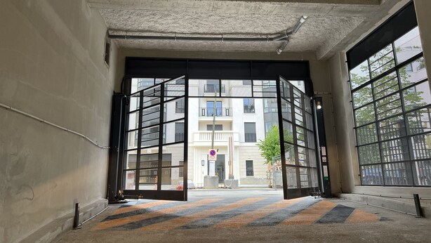 An interior corridor with a large open door leading to a building with a no parking sign. - Appartement 6 personnes, 5mn Disneyland Paris, Val d'Europe + Captain America ++ (Chessy)