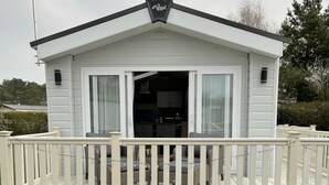 A white mobile home with a deck, a kitchen visible inside, and a sign that reads "Regal" on the roof. - Stunning Lodge in a Nice Area, Saint Leonards (Ringwood)