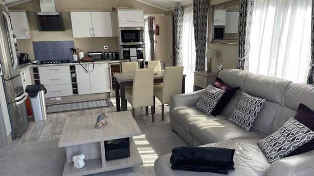 A modern living room with a sofa, coffee table, and dining area. - Stunning Lodge in a Nice Area, Saint Leonards (Ringwood)