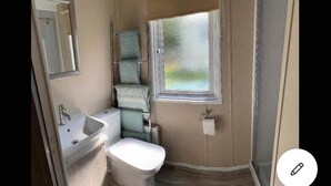 Une petite salle de bain comprenant un lavabo, des toilettes et une fenêtre.
