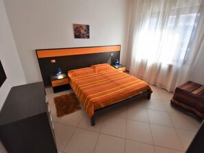 Une chambre à coucher avec un grand lit, une table de chevet, un bureau et une chaise.