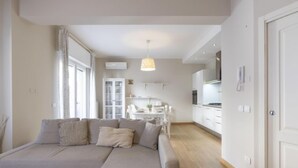 Ein modernes Wohnzimmer mit einem großen Ecksofa, einem Essbereich und einer Küche.