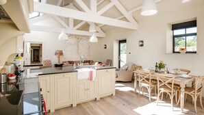 Cozinha espaçosa com uma ilha grande, piso de madeira e área de refeições com mesa e cadeiras.
